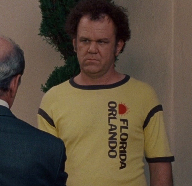 a man in a yellow shirt standing next to an older man