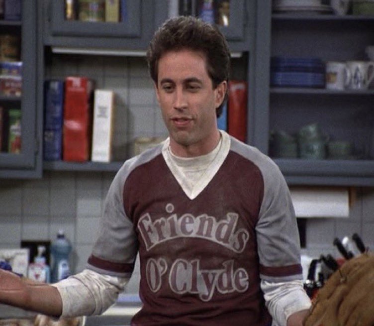 a man standing in a kitchen holding a baseball glove