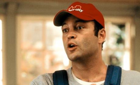 a man wearing a red baseball cap with the word "CITY" on it, looking off to the side with a surprised expression.