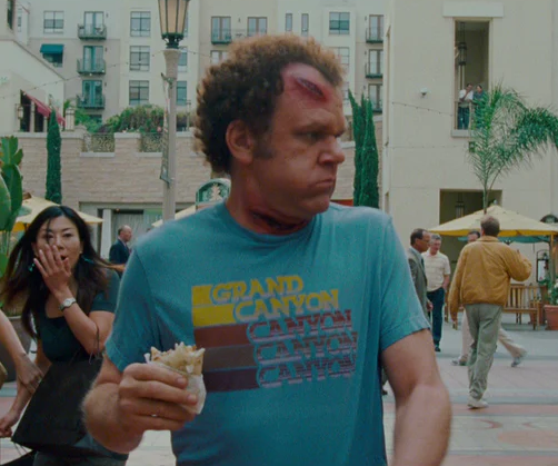 a man in a blue shirt eating a sandwich