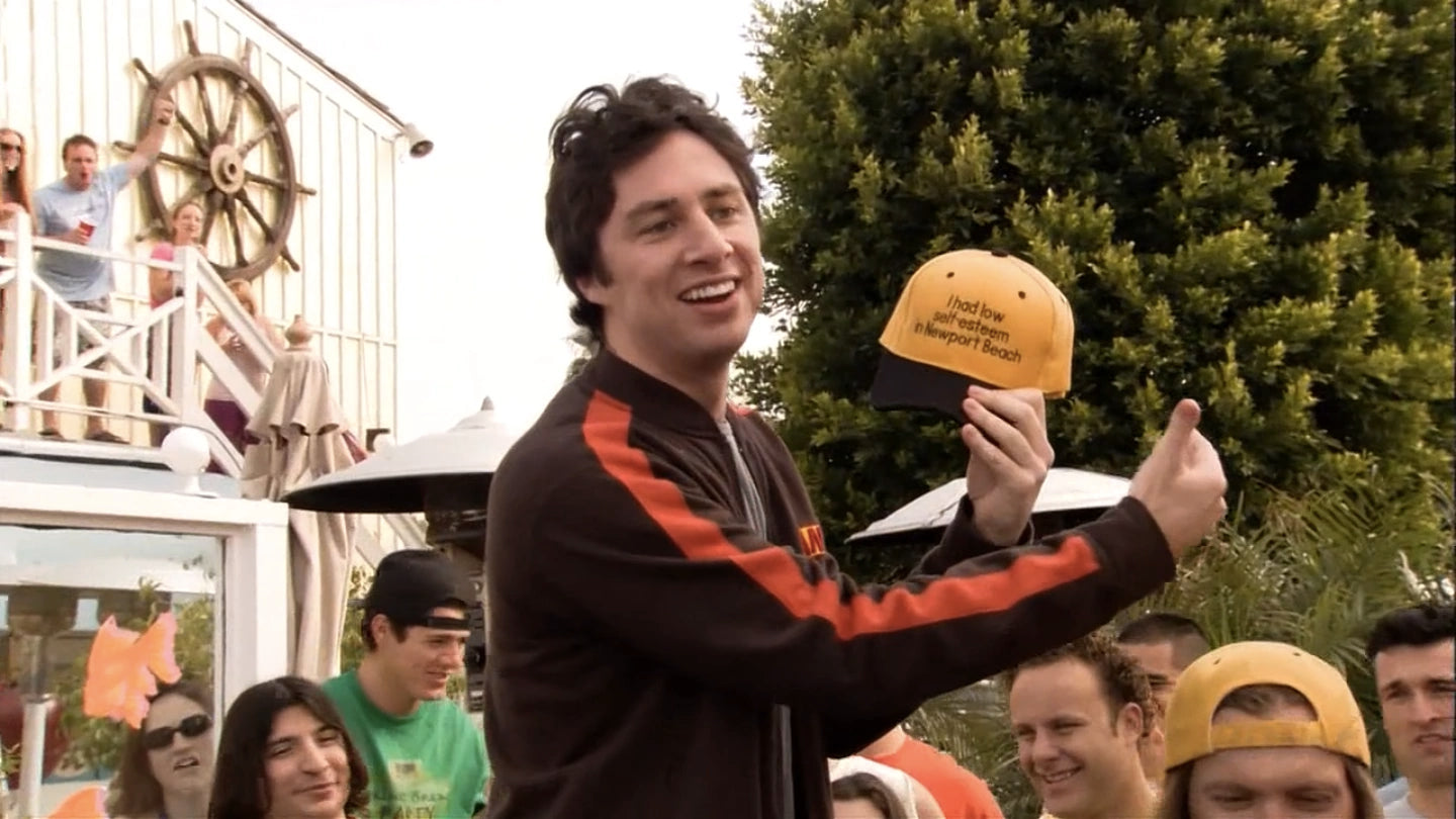 a man holding a yellow hat in front of a crowd of people