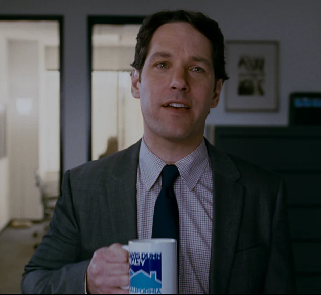 a man in a suit and tie holding a coffee mug