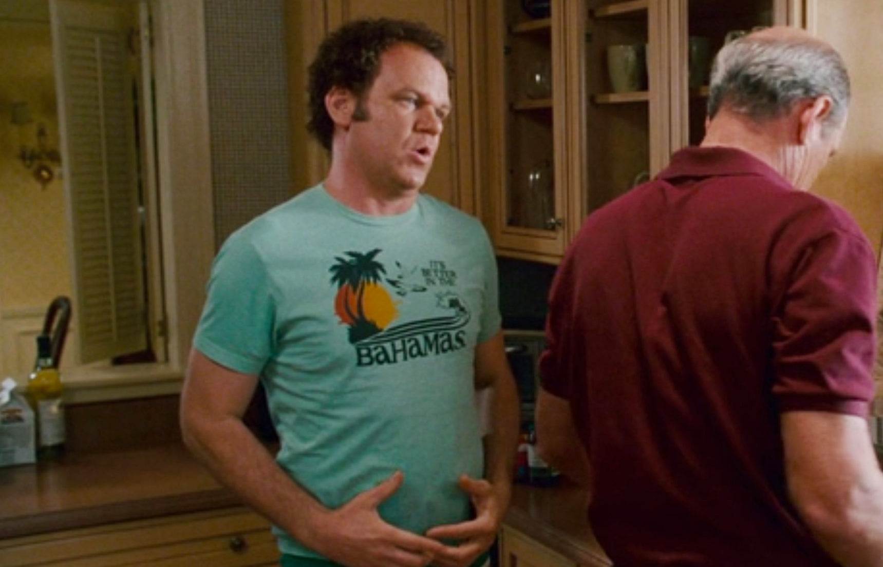 two men standing in a kitchen talking to each other