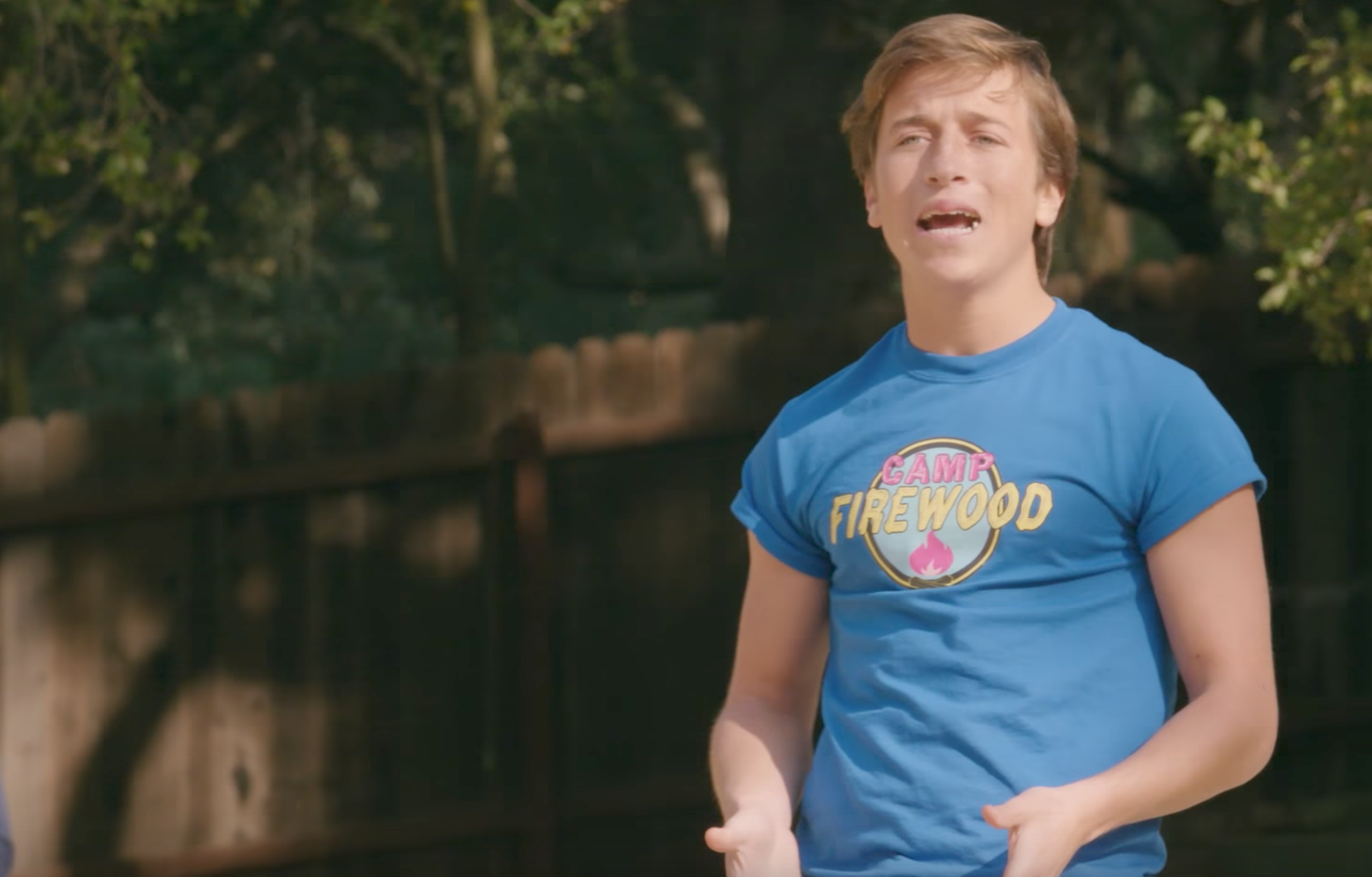 a young man in a blue shirt holding a frisbee