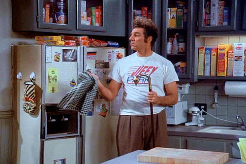 a man standing in front of a refrigerator in a kitchen