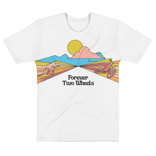 A white retro t-shirt that says "Forever Two Wheels" with two motorcyclists blending into the yellow, pink, and red scenery, blue mountains in the distance and clouds and sun in the sky.