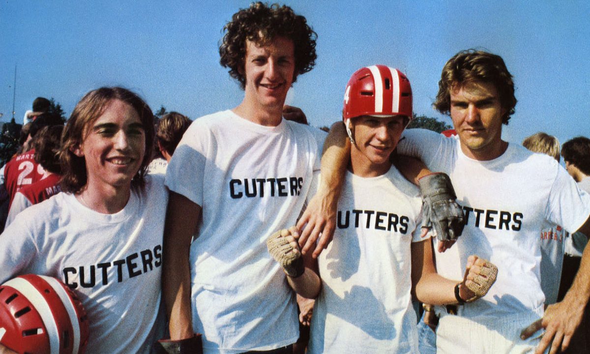 4 men in white t-shirts with "CUTTERS" printed on them, posing together outdoors.