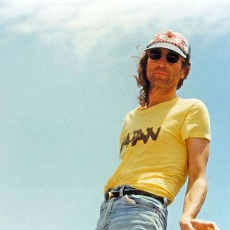 a man in a yellow shirt and hat holding a frisbee