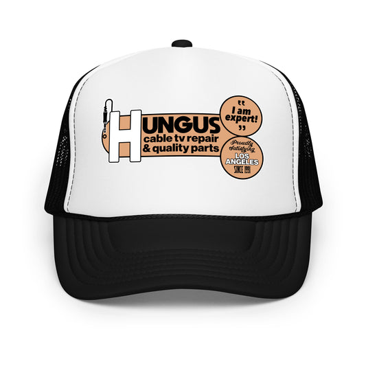 A travel black and white foam trucker hat that says Hungus cable tv repair & quality parts with a small electronic cable connector plug in image. Also says "I am expert!" and "Proudly Satisfying Los Angeles Since 1991". Refers to LA, California.