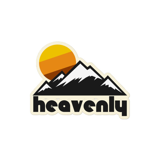 A retro kiss cut sticker which says 'heavenly' under the image of a mountain range, the peaks topped with snow, with a tricolored warm toned yellow, orange, and brown sun. References Heavenly Ski Resort, a popular skiing and snowboarding location at Lake Tahoe.