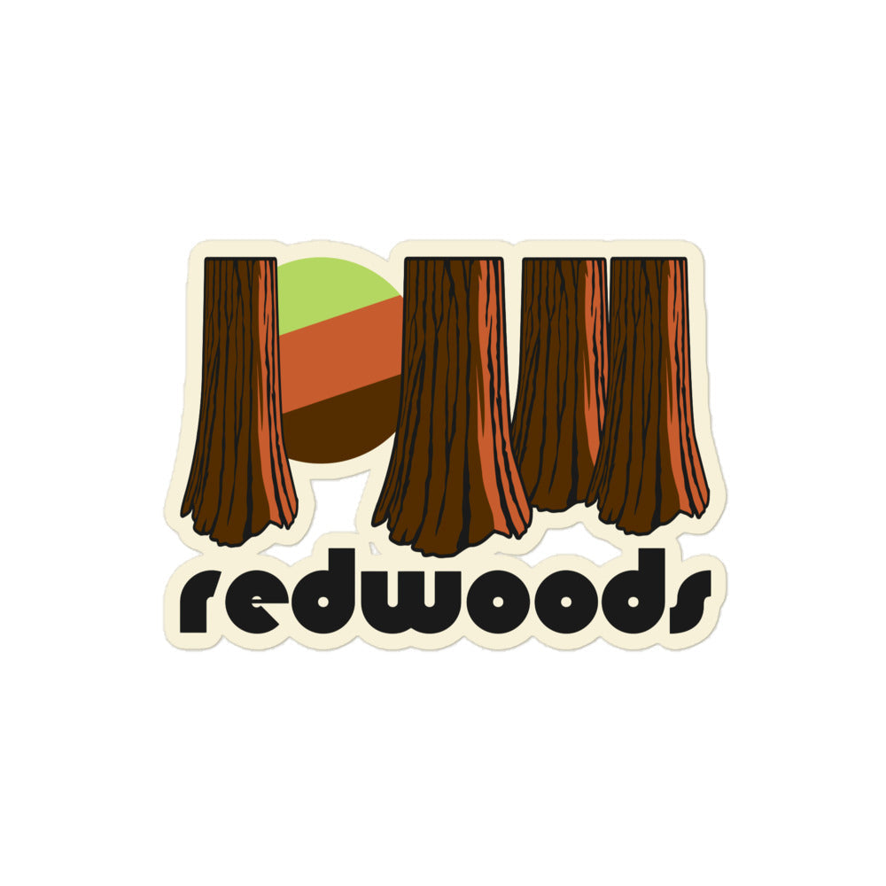 A retro kiss cut sticker that says 'redwoods' underneath the image of multiple redwood tree trunks, a green/brown sun peaking through the forest, referencing Redwood National and State Parks in California.