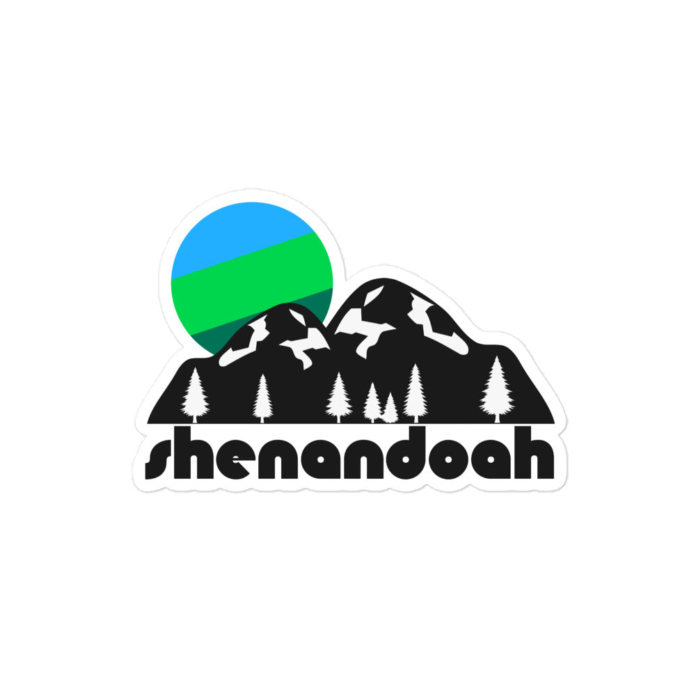 A vintage kiss cut sticker that says "Shenandoah" underneath the image of a black mountain landscape with snow and forest pine trees and a striped blue and green sun.