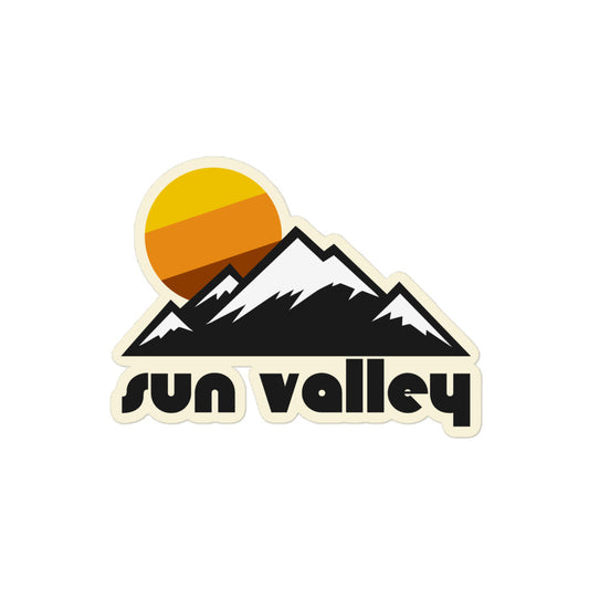 A vintage Sun Valley kiss cut sticker with the image of snowy mountains and a tricolored sun, referencing Sun Valley Resort on Bald Mountain and Dollar Mountain in Idaho.