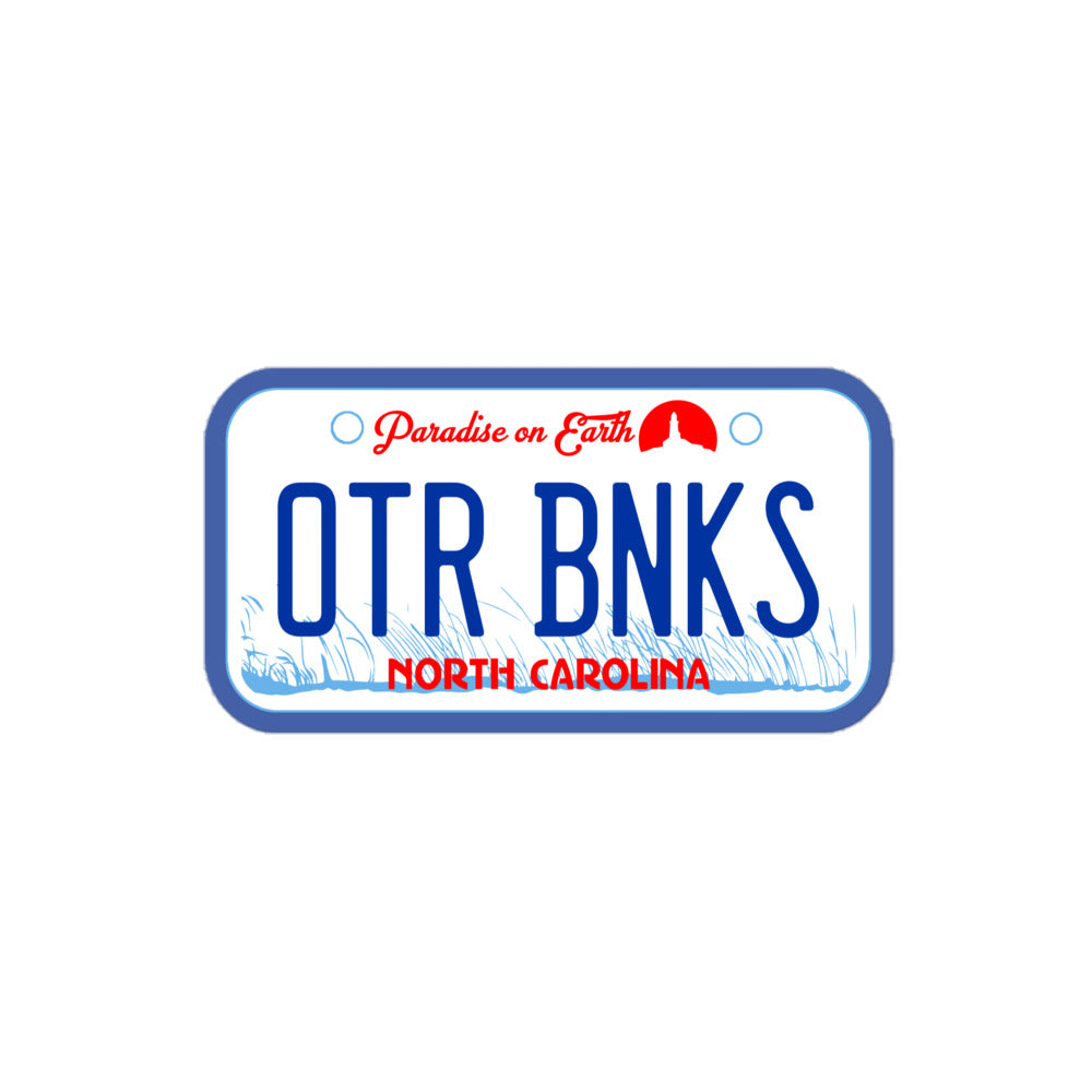 A souvenir retro Outer Banks kiss cut sticker made to look like a car license plate. Includes the letters "OTR BNKS" (Outer Banks), "North Carolina", and the catchphrase "Paradise on Earth" with the image of a small red lighthouse and blue sea grasses swaying. References the Netflix TV show quote by main character John B. Routledge, played by Chase Stokes.