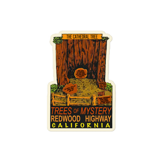A vintage kiss cut sticker that says "The Cathedral Tree" on top of a hollowed out tree trunk, "Trees of Mystery", "Redwood Highway", and "California. Images of a couple signs which read "Estimated Age Over 500 Years", "So Shall They Live When Ends Our Day", "Sink Down, Oh Traveler, On Your Knees, God Stand Before You In These Trees", and "Many Weddings Have Been Performed At This Site" in front of a wooden fence.