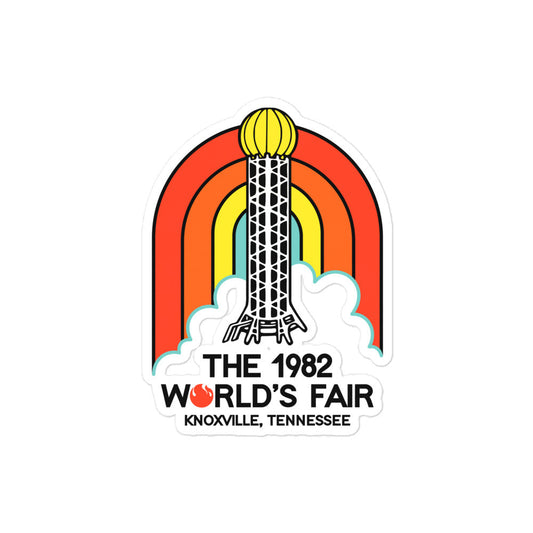 A kiss cut sticker that says "The 1982 World's Fair" with a fire for the "O" and "Knoxville, Tennessee". Image of a red, orange, yellow, and blue rainbow and the famous "Sunsphere" tower with a gold colored globe, used as the fair's symbol.