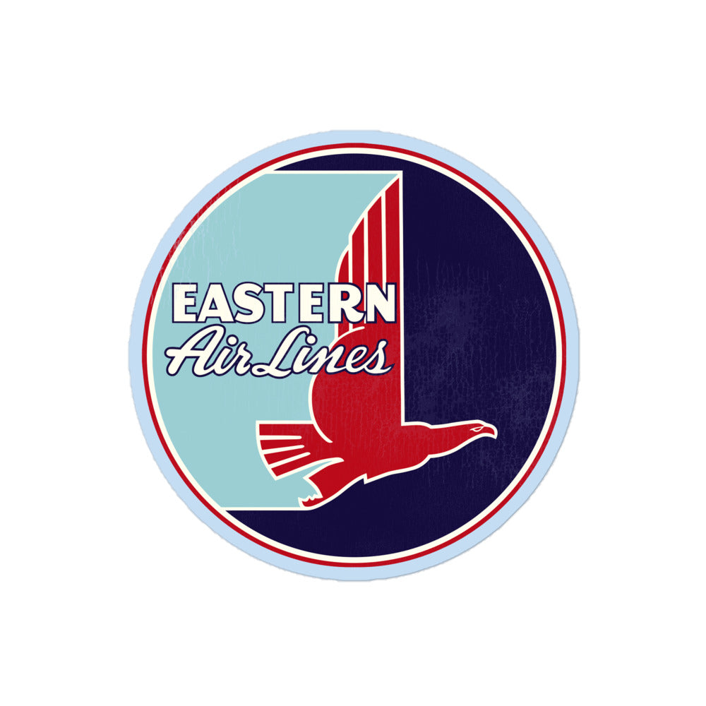 A circular tourist kiss cut sticker that says "eastern Air Lines" with its retro red falcon logo that resembles a hockey stick.