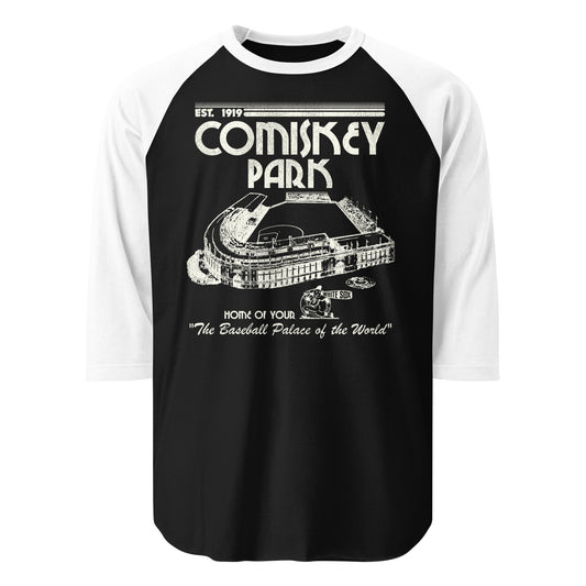 A black and white raglan retro style 3/4 sleeve shirt that says "Comiskey Park", "Home of Your White Sox", which was known as "The Baseball Palace of the World" and was "Est. 1919". Image of the stadium, originally known as White Sox Park, that was the home of the Chicago White Sox MLB team from the 1910s to the 1990s. Image of baseball player with a bat that says White Sox.