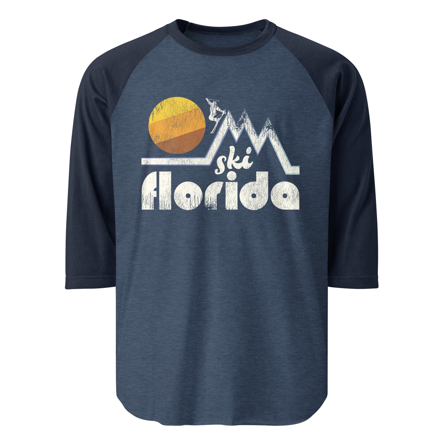 A retro raglan style 3/4 sleeve heather blue and navy blue shirt that says "Ski Florida" underneath images of mountain peaks with a skier and a large yellow, orange, and brown colored circular sun.