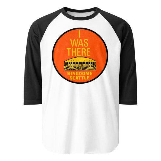 A three quarter sleeve black and white raglan style retro t-shirt that says "I Was There" and "Kingdome Seattle", also known as King County Stadium, a domed stadium in Seattle, WA which stood from 1976-2000 and housed the NFL team the Seattle Seahawks and the MLB team the Seattle Mariners.