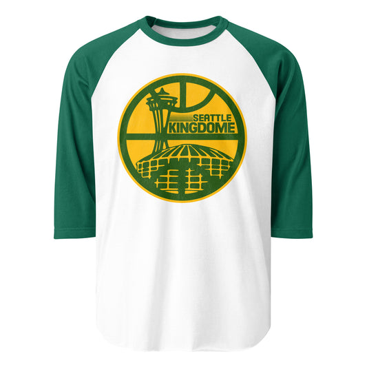 A 3/4 sleeve retro raglan style kelly green and white shirt that says "Seattle Kingdome", referencing the famous multipurpose stadium where MLB, NFL, NBA, and NASL teams played. Image of the Kingdome, or the King County Multipurpose Domed Stadium, in front of city icon tower the Space Needle, and overlayed by an image of a basketball court.