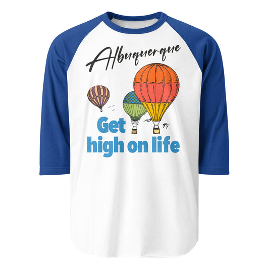 A blue and white three quarter sleeve raglan style vintage shirt that says Albuquerque and Get high on life. Images of three hot air balloons soaring through clouds, representative of the yearly Albuquerque International Balloon Fiesta.