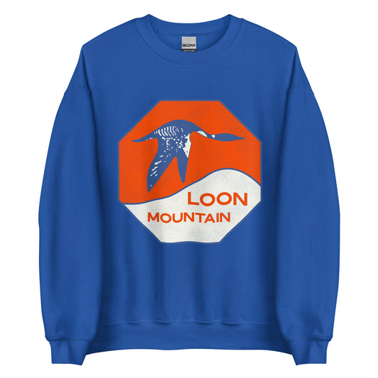 A retro style crew neck royal blue sweatshirt that says "Loon Mountain" referring to the New Hampshire skiing and snowboarding Loon Mountain Retreat in the White Mountain National Forest. Picture of a loon flying over white mountains against an orange sun background.