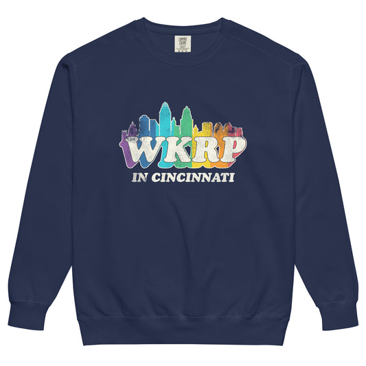 A retro true navy blue WKRP in Cincinnati crew neck sweatshirt with a rainbow colored skyline image of the Ohio city. Name of the 70s and 80s sitcom that ran on CBS.