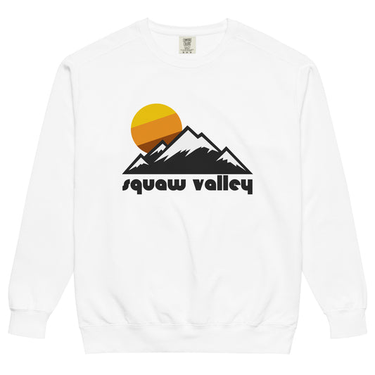A white crew neck retro sweatshirt that says "Squaw Valley" (now known as Palisades Tahoe Ski Resort) under an image of a mountain landscape, the peaks snow covered, with a circular striped yellow, orange, and brown sun setting.