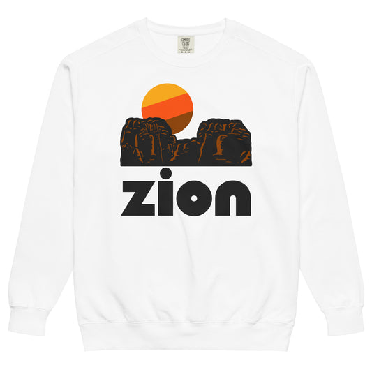 A white colored retro souvenir Zion National Park crew neck sweatshirt with the image of red rock cliffs and a sun rising behind. References Zion National Park in Utah, home to stunning hikes like Angels Landing, Zion Canyon, the Emerald Pools, and the Zion Narrows hike.