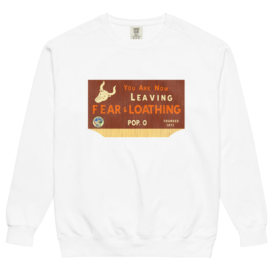 A vintage white colored crew neck sweatshirt which says "You are Now Leaving Fear & Loathing", in reference to the movie and book 'Fear and Loathing in Las Vegas'. Sweatshirt also says "Pop. 0" and "Founded 1971" with images of the Seal of Las Vegas, saying "City of Las Vegas, Nevada", and a cow skull with horns from the desert.