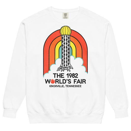 A white crew neck sweatshirt for tourists that says "The 1982 World's Fair" from "Knoxville, Tennessee". Image of a red, orange, yellow, and blue rainbow and clouds and the famous Sunsphere steel tower with a gold colored globe on top, an iconic image of the fair with its theme of "Energy Turns the World".