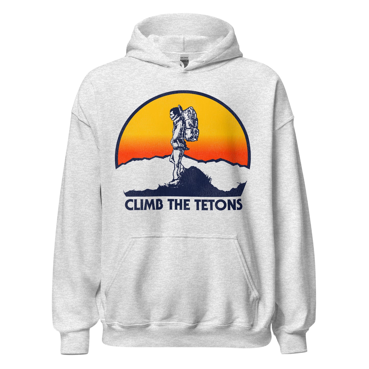 An ash colored 70s style tourist hooded sweatshirt that says Climb the Tetons, referencing the famous hiking destination spot, the Teton Range, named for its tallest peak, Grand Teton, and one of the most famous national parks in the United States. Image of a hiker with a large backpack at the top of a mountain, peaks in the distance as a yellow and orange sun sets.