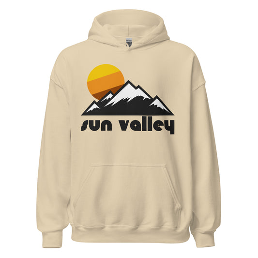 A sand colored Sun Valley Resort hooded sweatshirt that says "Sun Valley" underneath the image of snow covered peaks and a yellow, orange, and brown colored sun. Known for its incredible ski trails on Bald Mountain and Dollar Mountain, in the Smoky Mountains and Pioneer Mountains, the resort town was made famous by Ernest Hemingway.