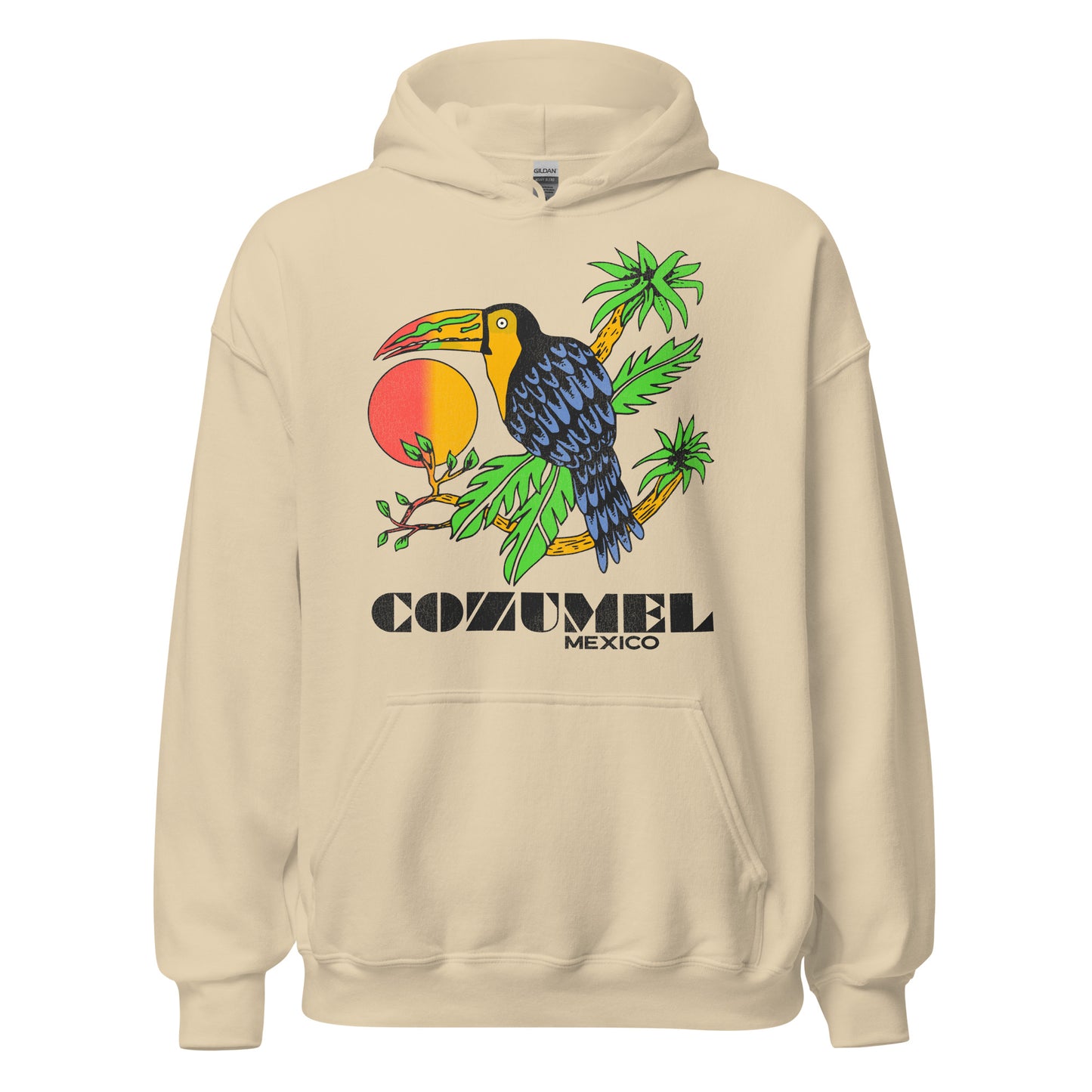 A sand colored travel hoodie sweatshirt with a blue toucan bird with a large red and yellow hombre beak sitting on island palm branches with an orange and red sun in the back. Text says "Cozumel Mexico" referring to the island off the east coast of the Yucatán Peninsula in the Caribbean Sea, a popular tropical cruise ship destination.