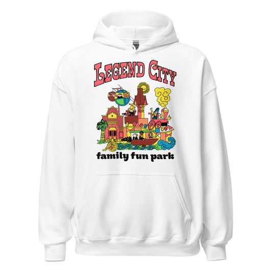 A 90s style retro white hoodie sweatshirt that says "Legend City family fun park" in reference to the theme park in Arizona that opened in the 1960s and closed in the 1980s. Images of children riding elevated trains, river boats, in sky rides, and on theme park rides. Images of a yellow sun smiling, a cannon going "Boom", green palm trees, and cute pink buildings.