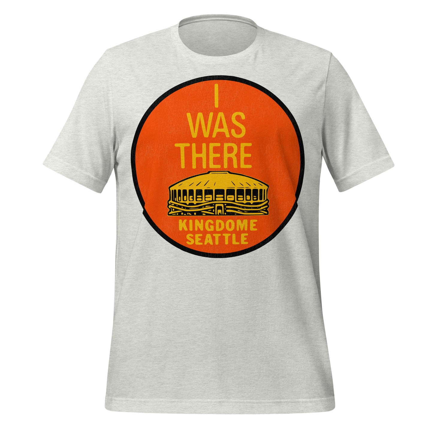An ash gray 80s style t-shirt that says "I Was There" and "Kingdome Seattle", a multi-purpose stadium which stood from 1976-2000, home of the Seattle Seahawks NFL team and the Seattle Mariners MLB team. Now replaced by Lumen Field and T-Mobile Park. Image of an orange circle with the iconic stadium in yellow.