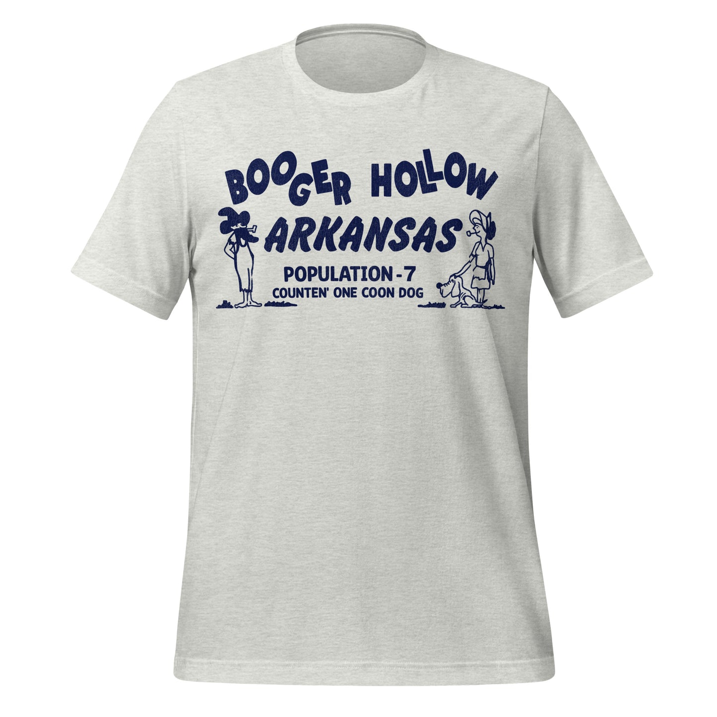 A travel ash colored t-shirt that says Booger Hollow Arkansas referring to the abandoned town off the Scenic 7 Byway with the words Population - 7 Counten' One Coon Dog. Includes a man a witch hat with a pipe and a woman with a pipe and a dog.