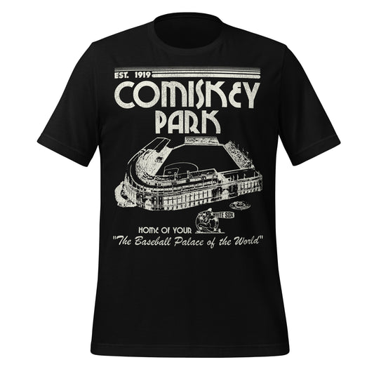 A black vintage short sleeve t-shirt that says Comiskey Park, Home of Your White Sox, and "The Baseball Palace of the World" and was "Est. 1919". References the historic home stadium for the Chicago White Sox in the years 1910-1990 and first known as White Sox Park. Image of the huge baseball stadium and a baseball player with a bat that says "White Sox".