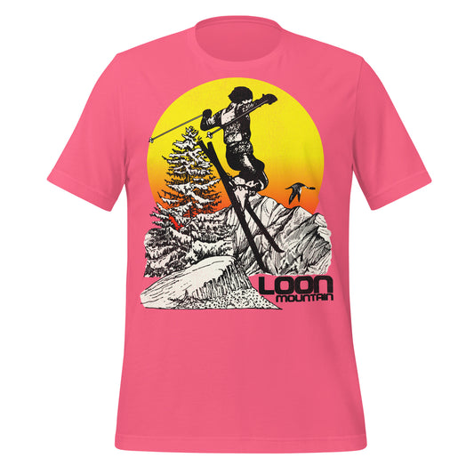 A bright charity pink vintage travel t-shirt that says "loon Mountain" with the image of a man skiing by a mountain range and trees covered in snow by a bright yellow, orange, and red sunset. A loon bird flies by.