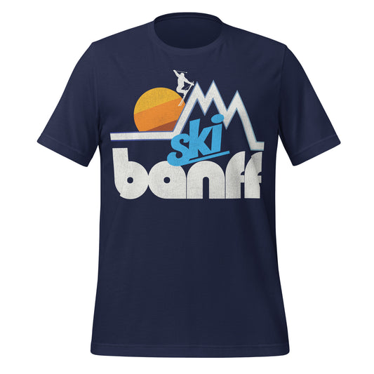A retro, 1970s style Ski Banff t-shirt with the picture of a mountain range landscape, a skier headed down a slope, and a rising sun. References Canada's first national park in the Alberta Rocky Mountains.