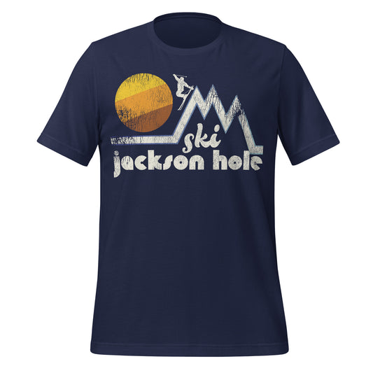 A retro 80s style "Ski Jackson Hole" navy colored t-shirt with the image of a skier doing a stylized jump off of one of three mountain peaks in front of a circular, colorful sun.