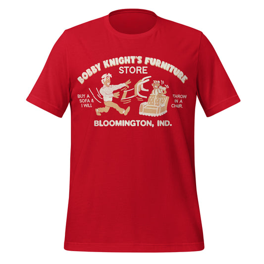A red vintage Bobby Knight's Furniture Store t-shirt from Bloomington, Indiana. Says "Buy a sofa & I will throw in a chair" Image of terrifying man throwing a chair at a terrified man who's hiding behind a couch.