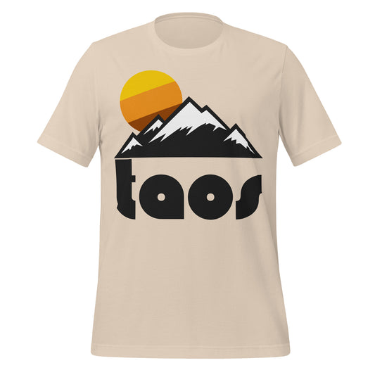A retro, 60s style "Taos" soft cream t-shirt with an image of a mountain landscape, perfect for skiing, covered in a light dusting of snow, a sun rising in the background. References Taos Ski Valley on Taos Mountain in New Mexico, near the Rio Grande Gorge and Rio Grande River, known for its steep ski trails, ice skating, and amazing hiking in the summer.
