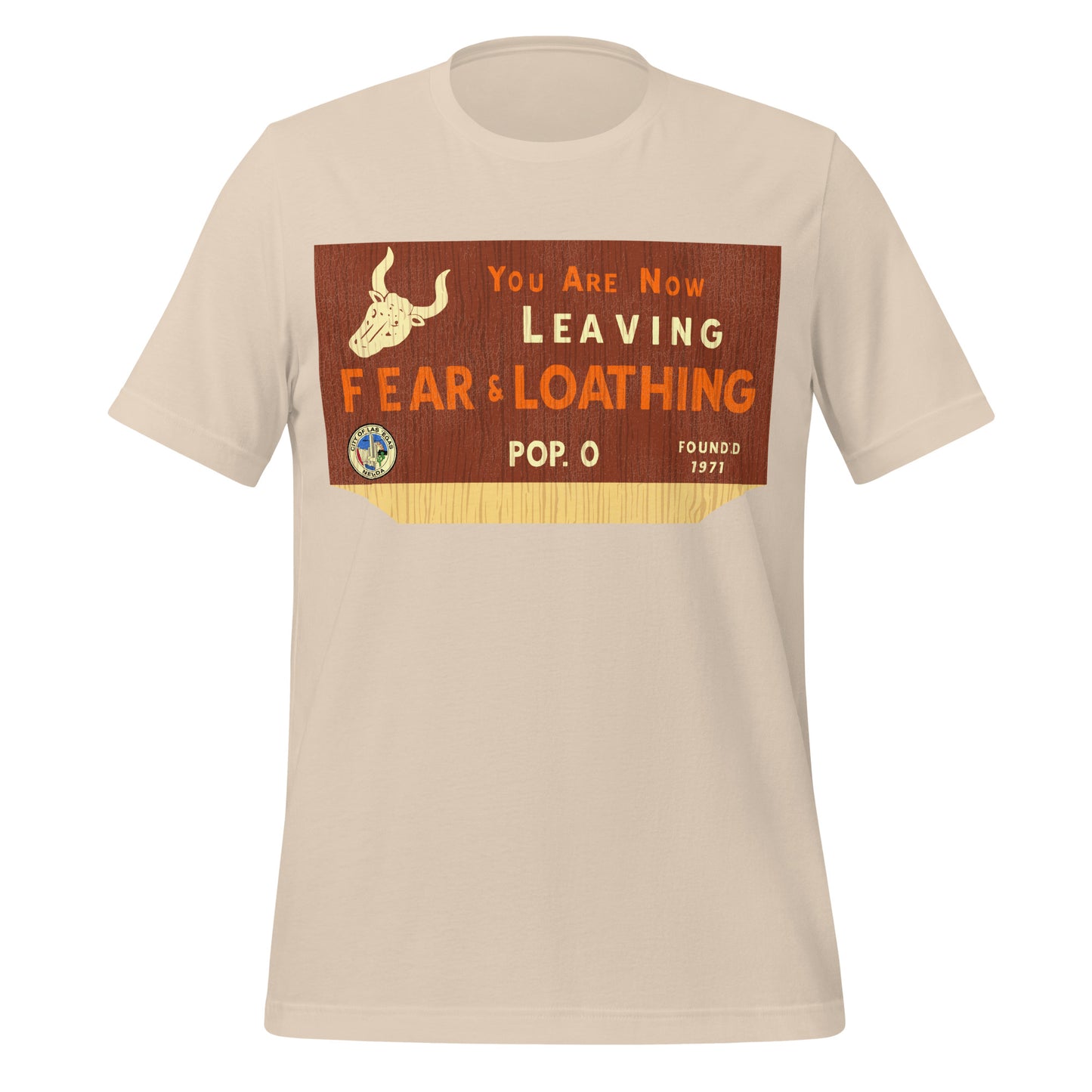 A 70s style soft cream t-shirt for tourists which reads "You are Now Leaving Fear & Loathing", "Pop. 0", and "Founded 1971". Image of the Seal of Las Vegas which says "City of Las Vegas, Nevada" and a horned bull skull on a background which resembles wood. In reference to the film 'Fear and Loathing in Las Vegas' based on the novel by author Hunter S. Thompson.
