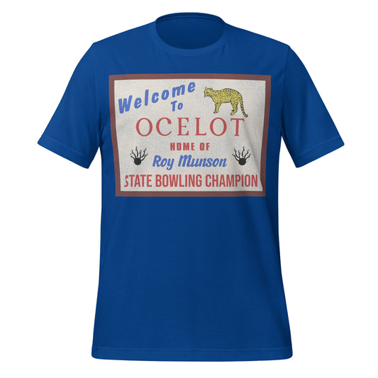 A 90s style unisex royal blue staple t-shirt with short sleeves that says "Welcome to Ocelot Home of Roy Munson State Bowling Champion" with a yellow ocelot image and bowling pins with bowling balls referring to Kingpin the blockbuster movie and Ocelot, Iowa.