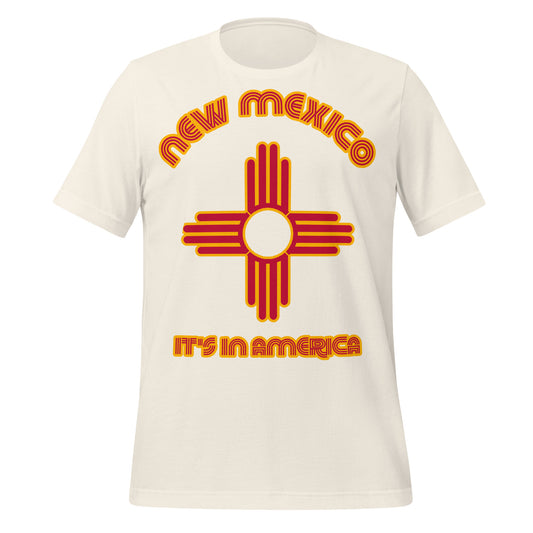 A vintage white colored short sleeved retro New Mexico t-shirt that says "It's in America" in red and yellow colors with the symbol from the Zia tribe, representing a sun design, and also north, south, east, and west as well as the four stages of life, now found on the modern NM state flag.