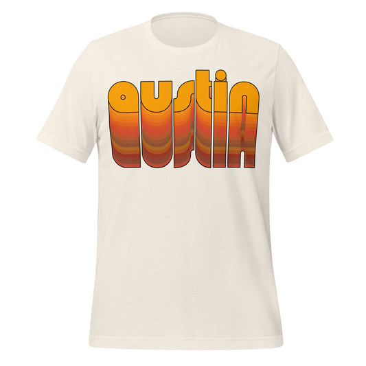 A vintage white colored 1970s style souvenir Austin, Texas t-shirt with the word Austin in orange reflected underneath in various shades of reds, yellows, greens, and oranges.