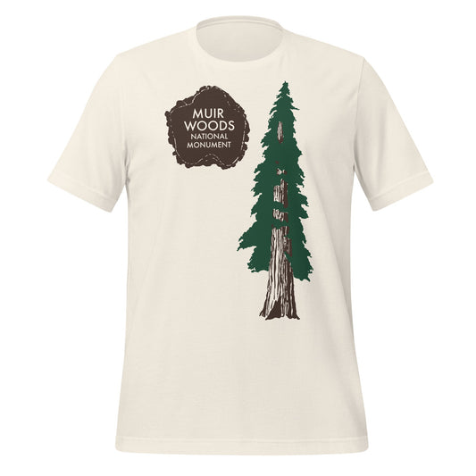 A vintage white 80s style tourist t-shirt that says "Muir Woods National Monument" on top of a brown paw print next to a beautiful pine tree, part of California's Golden Gate National Recreation Area.