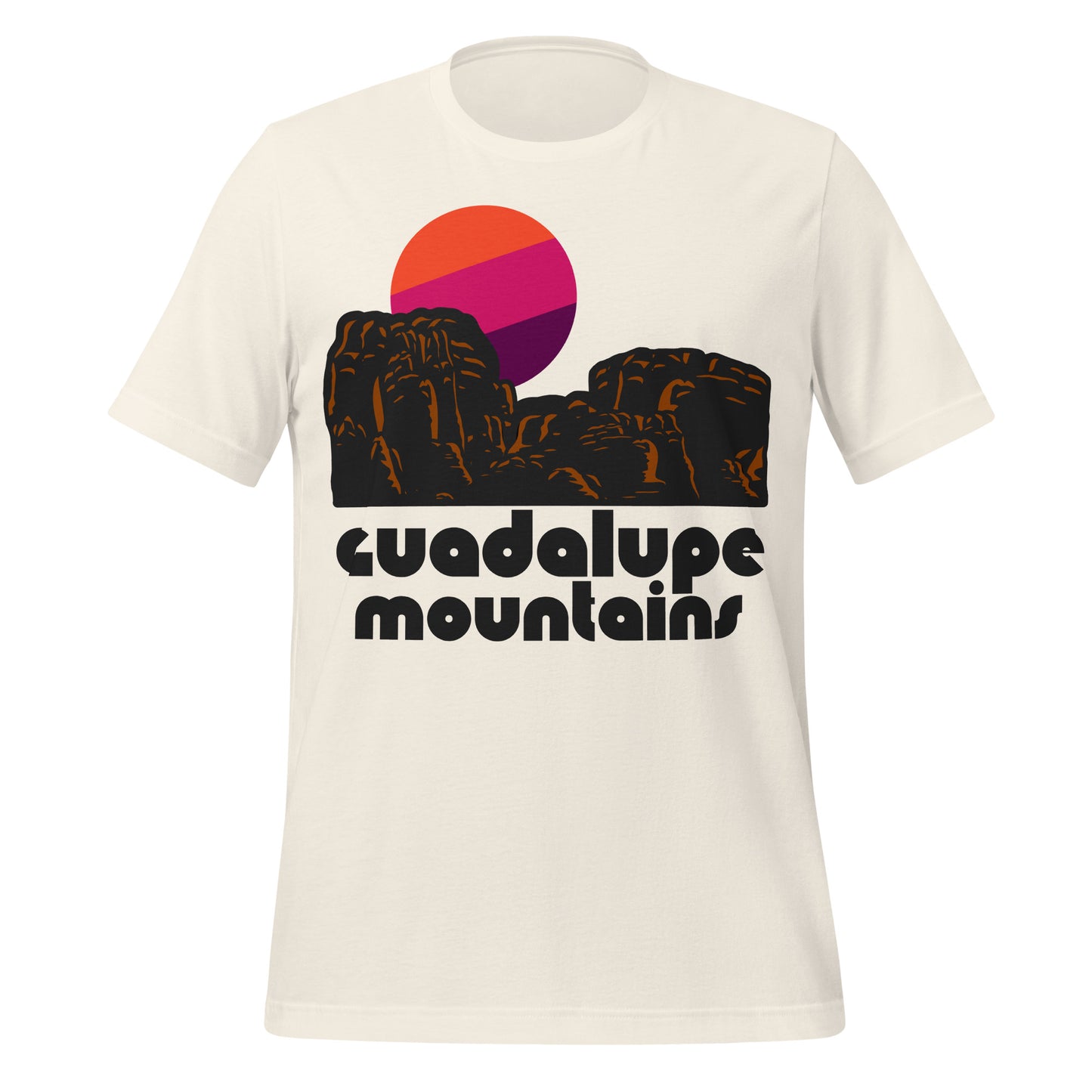 A vintage off-white t-shirt for travel that says "Guadalupe Mountains" and has image of red rocks and desert in front of an orange, pink, and purple sun rising. References the national park.